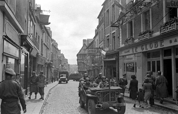 NARA/Soldats américains et britanniques dans la rue principale de Bayeux, qui n’a guère changé depuis la Seconde Guerre mondiale. NARA/Soldats américains et britanniques dans la rue principale de Bayeux, qui n’a guère changé depuis la Seconde Guerre mondiale.