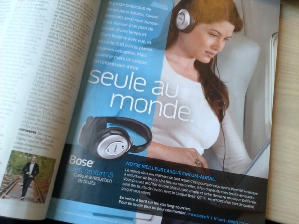 Une executive woman dans une cabine d'avion avec le casque sur les oreilles, et un argumentaire imparable : "Vous avez besoin de calme.   Les cabines d'avion sont bruyantes. Achetez nos casques !"