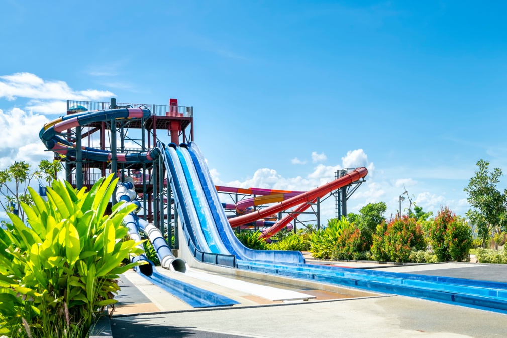 grand curseur coloré au parc aquatique d'attractions ou au parc aquatique dans une belle journée de ciel nuageux et bleu © Surasak - stock.adobe.com