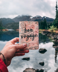 une personne tenant un carnet avec “bon voyage” écrit dessus © Wanderlabs