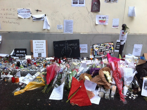 Passersby pay tribute to the journalists of Charlie Hebdo on the sidewalk in front of the newspaper’s office in the 11th arrondissement in Paris. DR-LAC