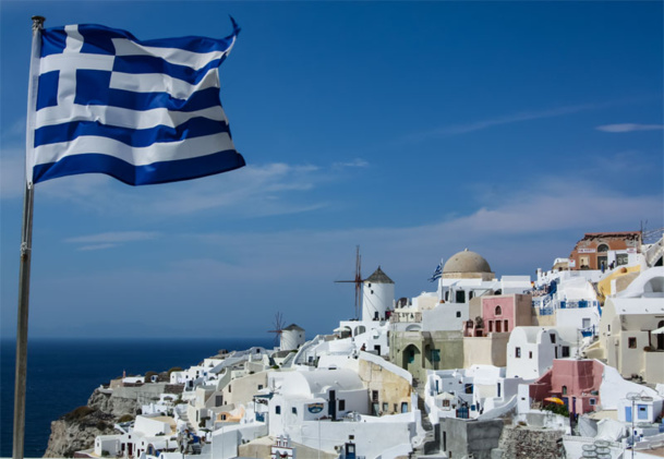 Le drapeau grec flottant au dessus de Santorin en Grèce. © zhukovandr - Fotolia.com Le drapeau grec flottant au dessus de Santorin en Grèce. © zhukovandr - Fotolia.com
