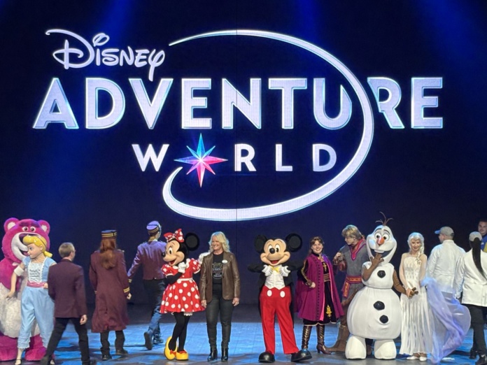 Au centre de la scène, Natacha Rafalski, présidente de Disneyland Paris, entourée des personnages emblématiques de l’univers Disney. ©David Savary