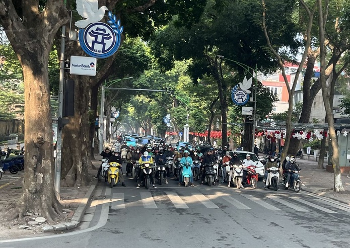 Dans les grandes avenues de Hanoï, les deux-roues avancent groupés en nuées gigantesques puis pilent aux feux rouges - Photo : PB
