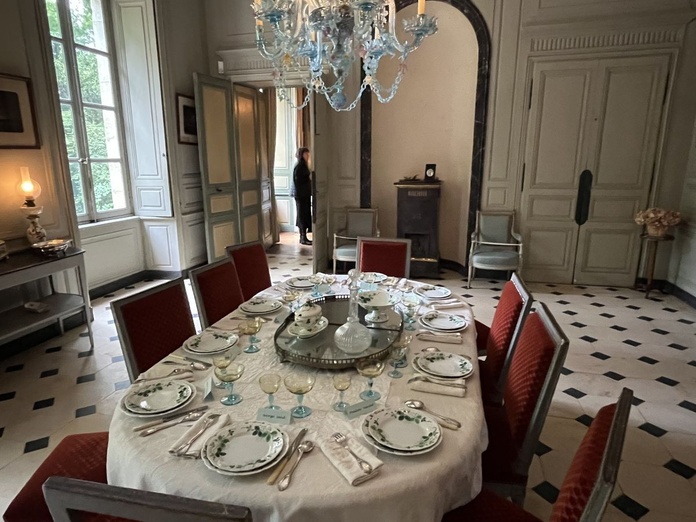 Dans la salle à manger éclairée par un liste de Murano, la table reste dressée avec les désormais célèbres assiettes à motif de fraises de la faïencerie de Creil-Montereau - Photo : Paula Boyer