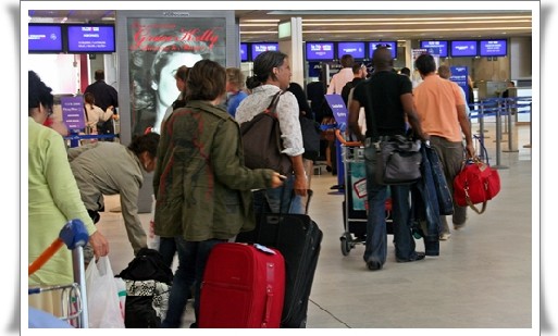 Une foutue queue digne du Guiness Book se hâtait lentement vers les comptoirs de «  dépose bagages »