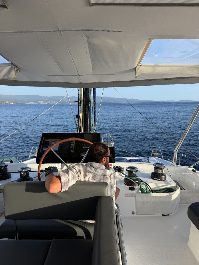 Paul, le capitaine, aux commandes de l'Orion au large des côtes corses. Une navigation entièrement prise en charge, pour des passagers qui n'ont qu'à profiter. - Photo PV