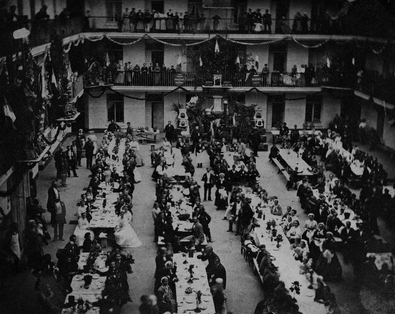 Banquet de la Fête du travail dans la cour du pavillon central, le 6 juin 1870. Le calendrier familistérien est rythmé par deux fêtes laïques inédites : la Fête de l’enfance se tient en septembre depuis 1863, et la Fête du travail créée en 1867 se célèbre le premier dimanche de mai. La Fête du travail familistérienne anticipe de deux décennies le Premier mai de la revendication de la journée de huit heures - DR : Familistère