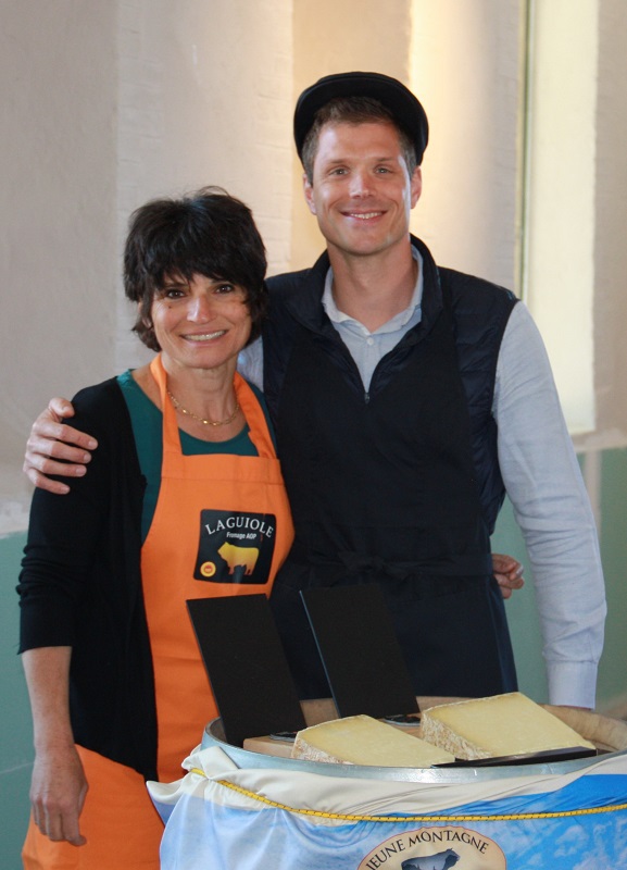 Maxime des Longchamps, gérant d’EscaleMED, et Hélène, guide gourmand Destination Occitanie du Domaine de l’Oulivie, se prêtent au jeu de faire déguster du laguiole, fromage de la Coopérative Jeune Montagne - DR : EscaleMED