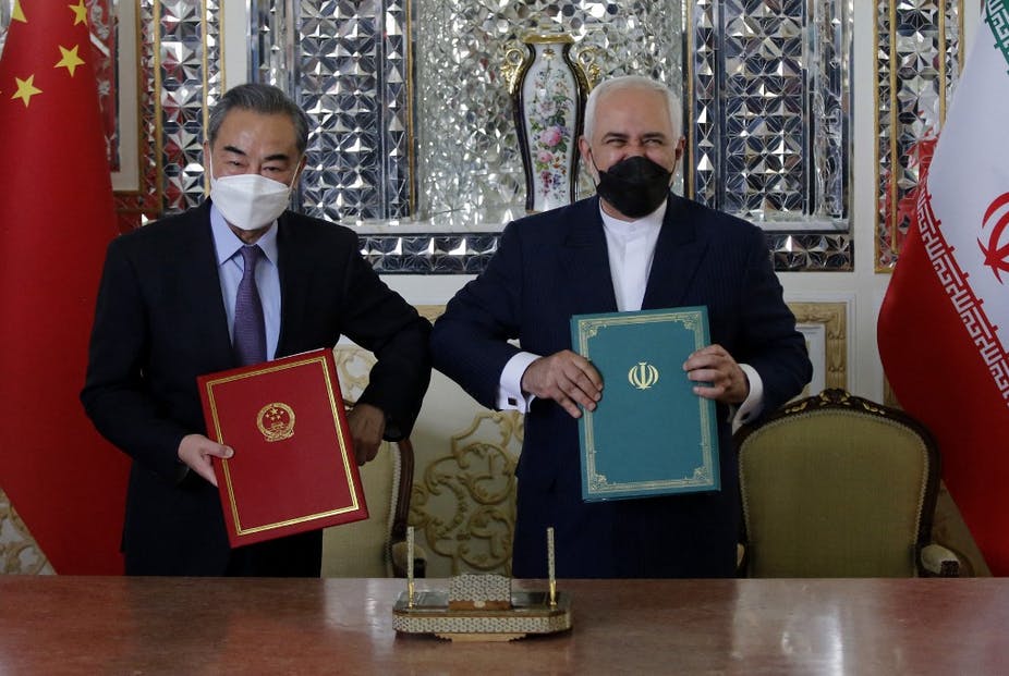 Le ministre iranien des Affaires étrangères, Mohammad Javad Zarif, et son homologue chinois, Wang Yi, posent après avoir signé un pacte de coopération stratégique à Téhéran, le 27 mars 2021. AFP