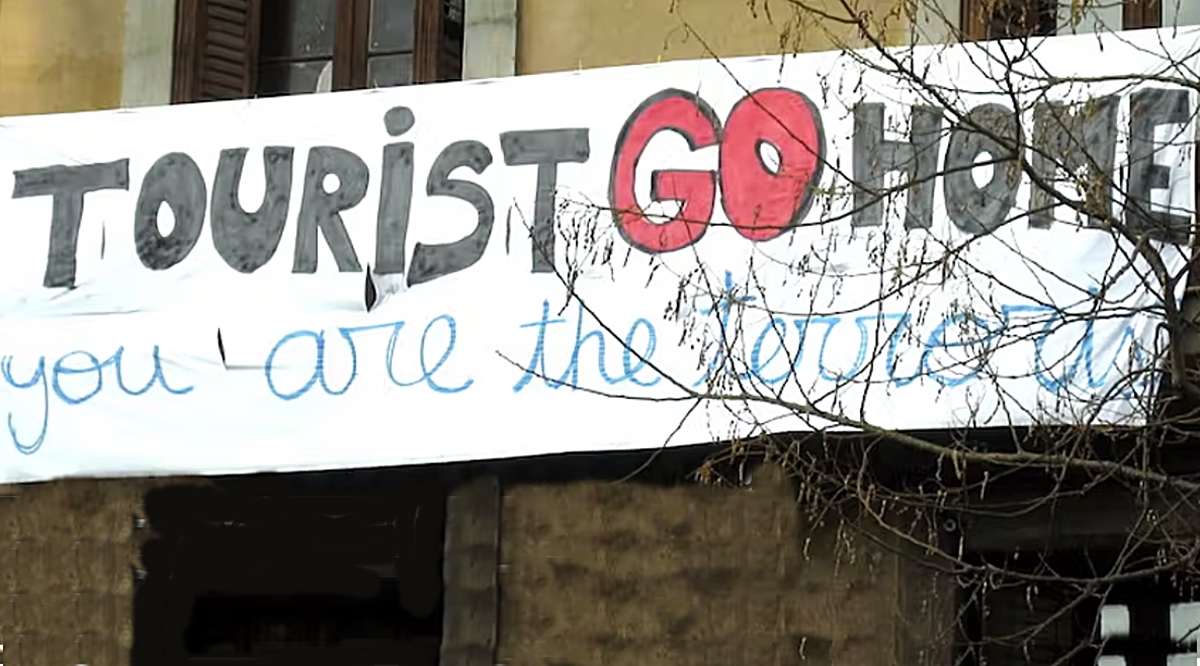 Banderole affichée sur un immeuble de Barcelone, en Espagne, sur laquelle on peut lire « touriste, rentre chez toi, c’est toi le terroriste ». Ben Freeman/Flickr, CC BY-SA