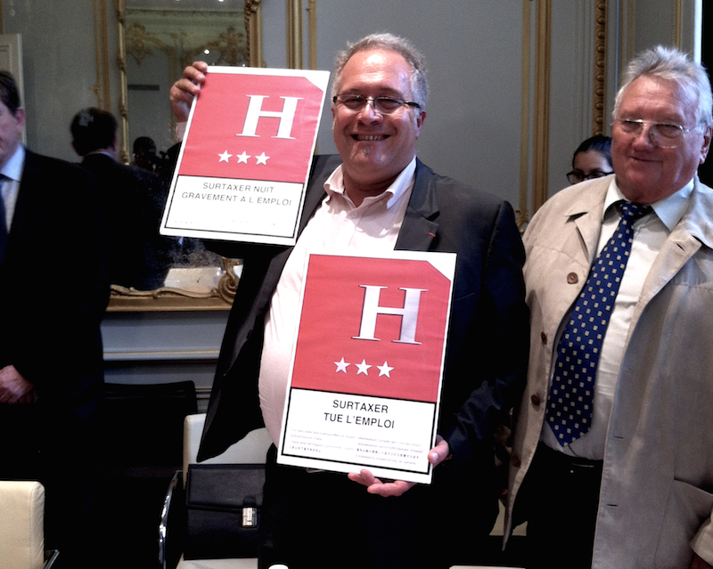 Laurent Duc, responsable de la branche hôtellerie à l'Umih, nous présente les panneaux qui seront installés à l'entrée des hôtels avant le 14 juillet. DR LAC