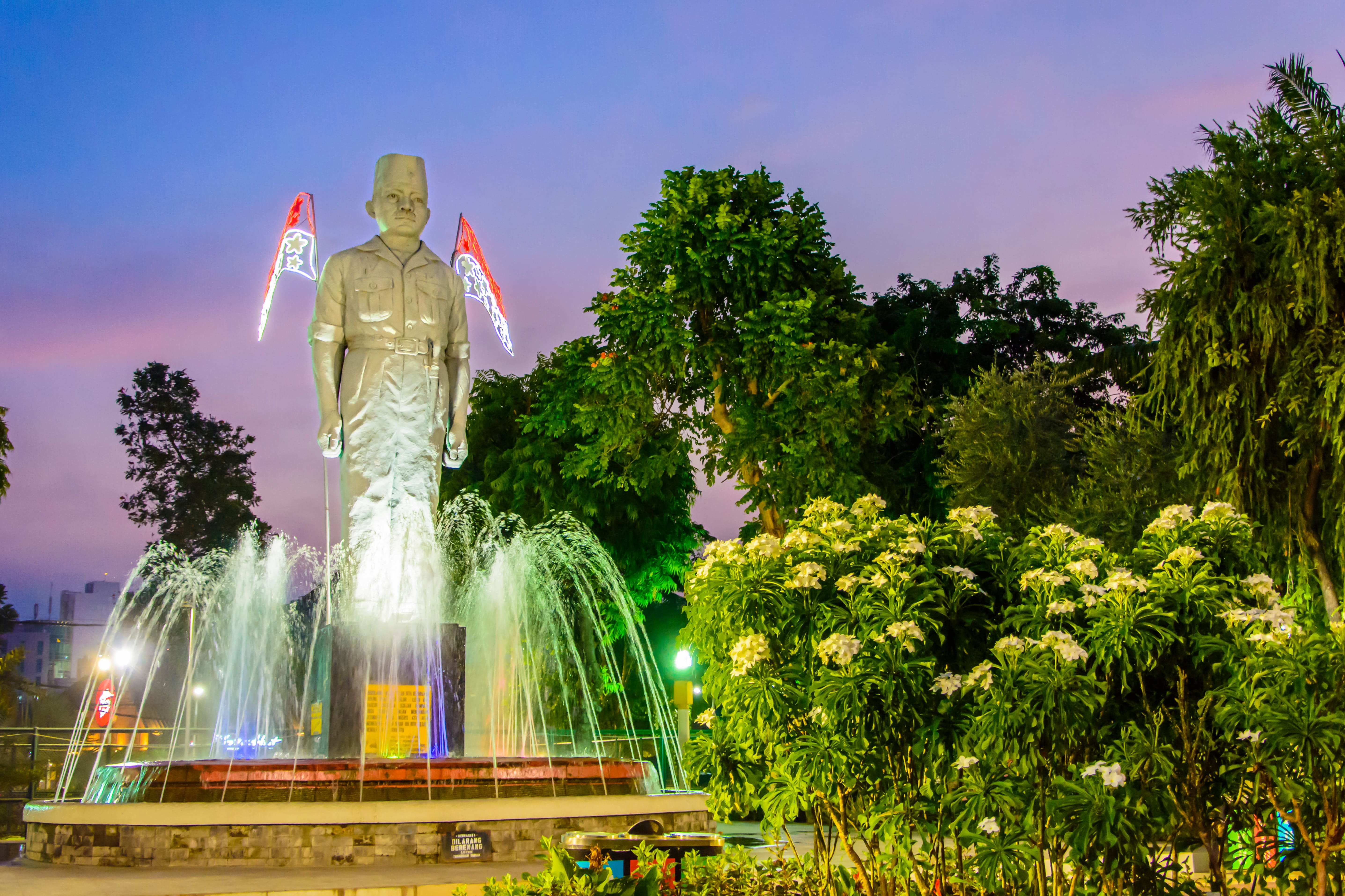 Statue du gouverneur Suryo, premier gouverneur de l'est de Java, dans le jardin de la ville de Taman Apsari à Surabaya au crépuscule © MonicaPriscilla - stock.adobe.com