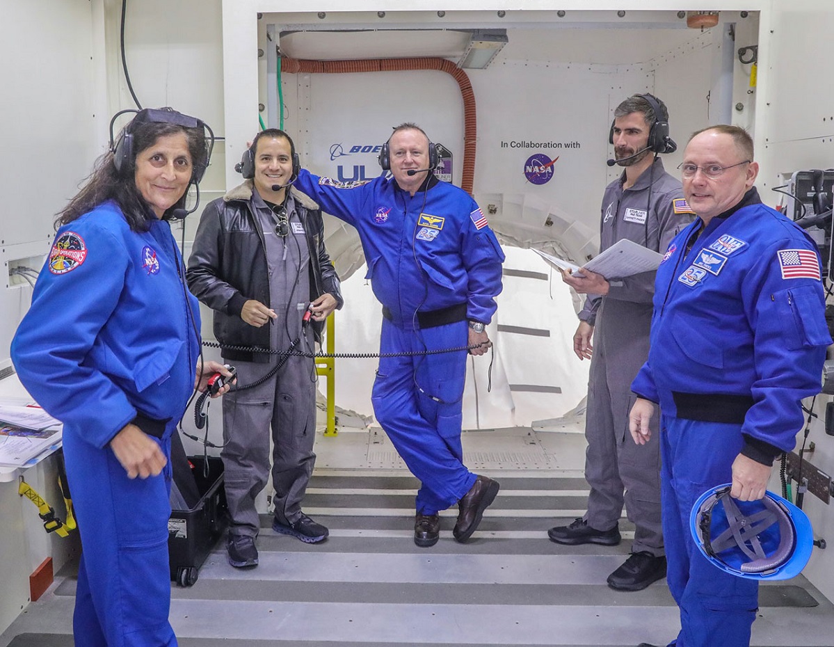 Les astronautes de la NASA (en bleu) Suni Williams (de gauche à droite), Butch Wilmore et Mike Fincke, avec les membres de l'équipe Starliner Pad Armando Loli (deuxième à partir de la gauche) et Garrett Pinder dans la salle blanche lors d'un exercice d'équipage intégré. (Photo de John Grant - Boeing)