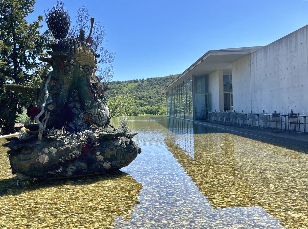 Devant l'auditorium conçu par Oscar Nemeyer, une oeuvre de Damien Hirst se reflète dans l'eau. C'est l'une des 10 sculptures monumentales posées sur le parcours Art et Architecture (©PB) Devant l'auditorium conçu par Oscar Nemeyer, une oeuvre de Damien Hirst se reflète dans l'eau. C'est l'une des 10 sculptures monumentales posées sur le parcours Art et Architecture (©PB)