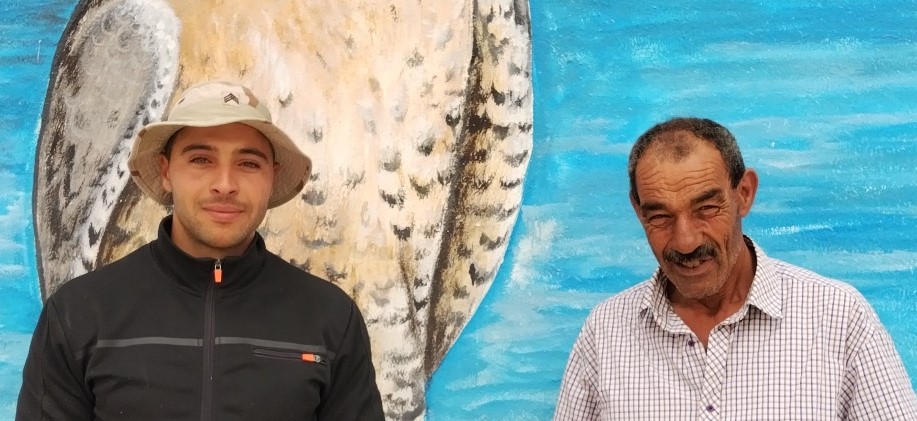 Côte à côte l’ancienne et la jeune génération des  fauconniers de Kerkouane devant une peinture murale de leur petit musée.MS.