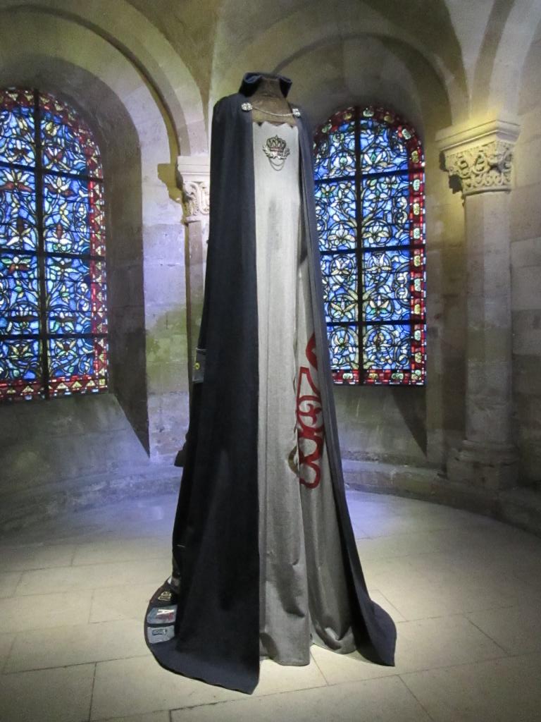 Blanche de France, duchesse d’Orléans (1328 - 1393). Fille posthume du roi Charles IV  le Bel.  Sa naissance marque l’extinction des capétiens directs et l’arrivée sur le trône des Valois. Elle épouse en 1345 son cousin Philippe de Valois, duc d’Orléans, fils du roi Philippe VI.  Cotte en blouson bleu, surcot en denim gris, gorgerin en dentelle dorée. Cape en jean bleu et poches-logo en décor. Photo MS. Blanche de France, duchesse d’Orléans (1328 - 1393). Fille posthume du roi Charles IV  le Bel.  Sa naissance marque l’extinction des capétiens directs et l’arrivée sur le trône des Valois. Elle épouse en 1345 son cousin Philippe de Valois, duc d’Orléans, fils du roi Philippe VI.  Cotte en blouson bleu, surcot en denim gris, gorgerin en dentelle dorée. Cape en jean bleu et poches-logo en décor. Photo MS.