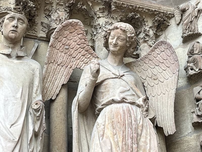 "L'ange au sourire" se trouve à gauche du portail nord de la façade occidentale - Photo : PB