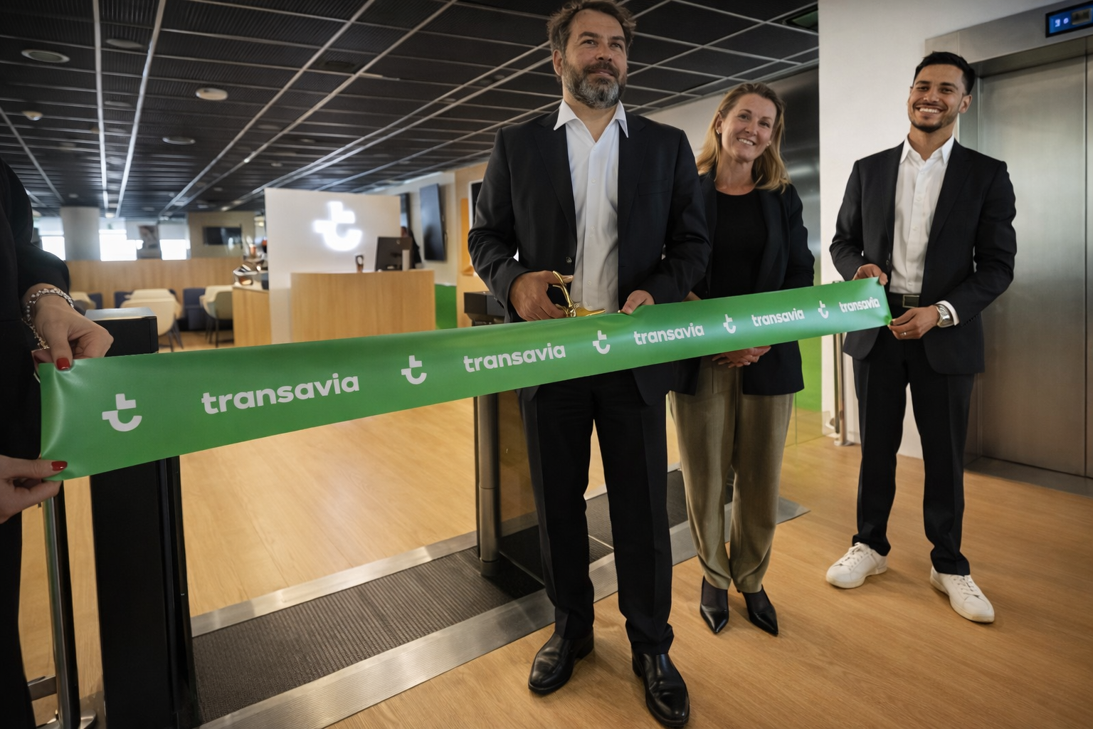 Julien Mallard, ciseaux en main, coupe le ruban du nouveau salon Transavia - Photo : C. Hardin