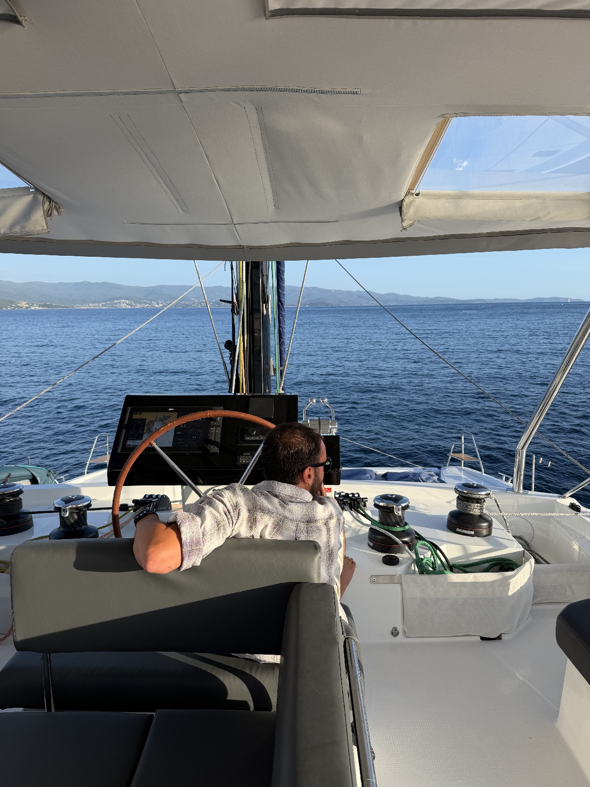 Paul, le capitaine, aux commandes de l'Orion au large des côtes corses. Une navigation entièrement prise en charge, pour des passagers qui n'ont qu'à profiter. - Photo PV